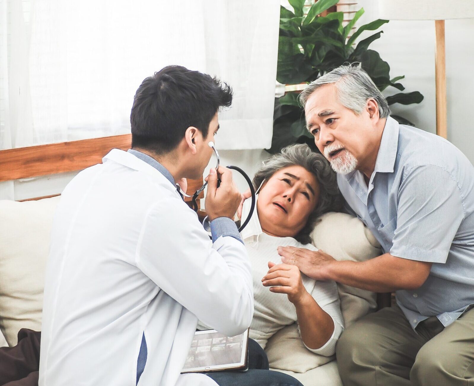 Doctor talking to elderly sick couple