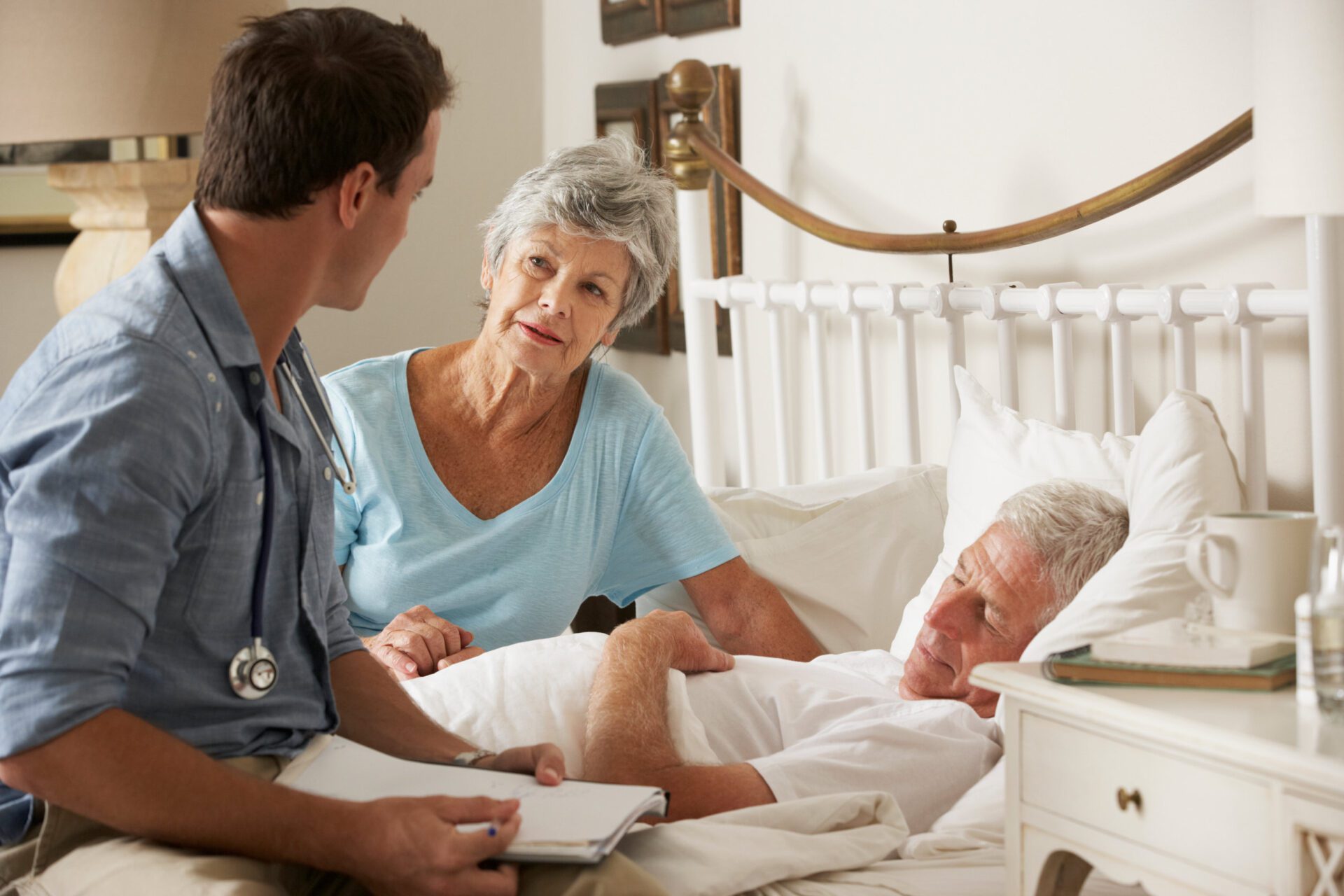 Doctor On Home Visit Discussing Health Of Senior Male Patient With Wife